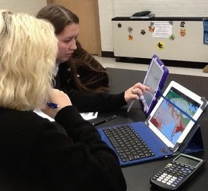 Two students use tablets to describe and explore the factors that influence climates in different regions of the world. 