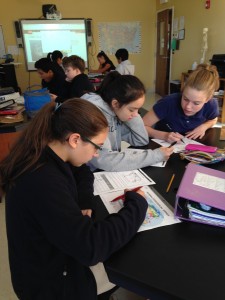 A group of there female students work on completing Extreme Journey worksheet
